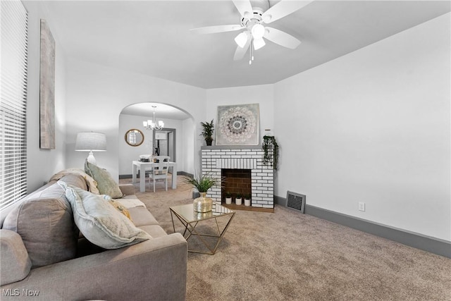 2602 Fletcher Ave NE, Canton, OH 44705 - carpeted living room featuring arched walkways, a chandelier, ceiling fan, and a brick fireplace