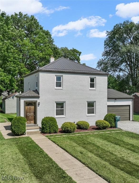 1146 Raff Rd SW, Canton, OH 44710 - view of front of property featuring a garage, a front lawn, brick siding, a metal roof, and a chimney