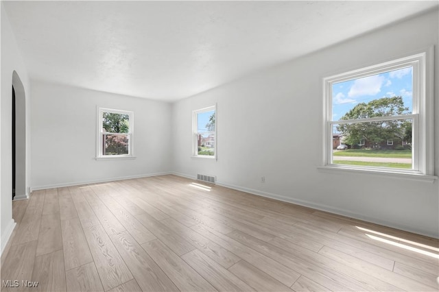 1146 Raff Rd SW, Canton, OH 44710 - empty room with arched walkways and light wood-style flooring