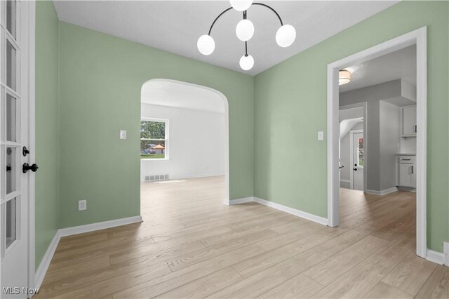 1146 Raff Rd SW, Canton, OH 44710 - empty room featuring arched walkways and light wood-style floors