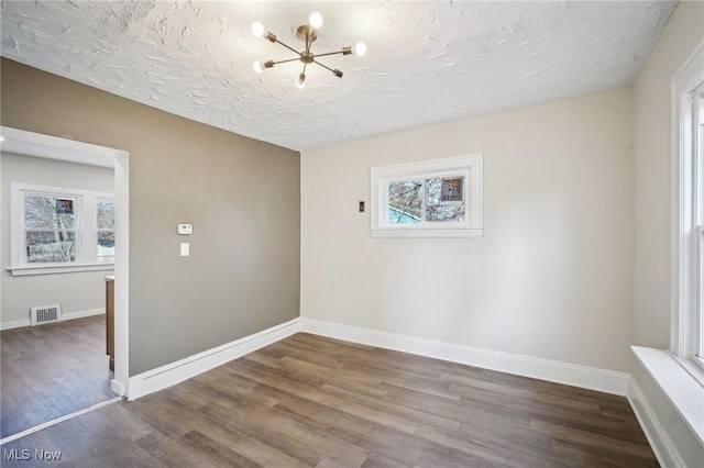 13713 Edgewood Ave, Cleveland, OH 44105 - spare room featuring plenty of natural light, wood finished floors, a chandelier, and a textured ceiling