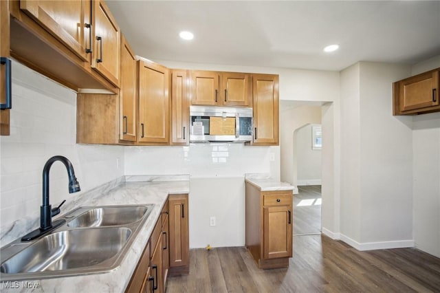 13713 Edgewood Ave, Cleveland, OH 44105 - kitchen with stainless steel microwave, dark wood-style flooring, backsplash, brown cabinets, and recessed lighting