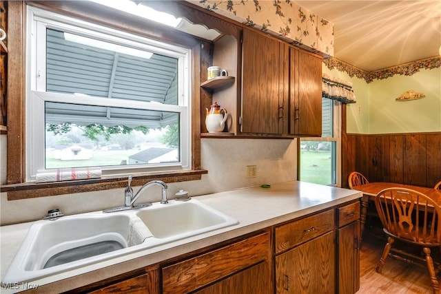 3985 Etter Rd, Mogadore, OH 44260 - kitchen featuring a wainscoted wall, light countertops, wood finished floors, wooden walls, and brown cabinetry