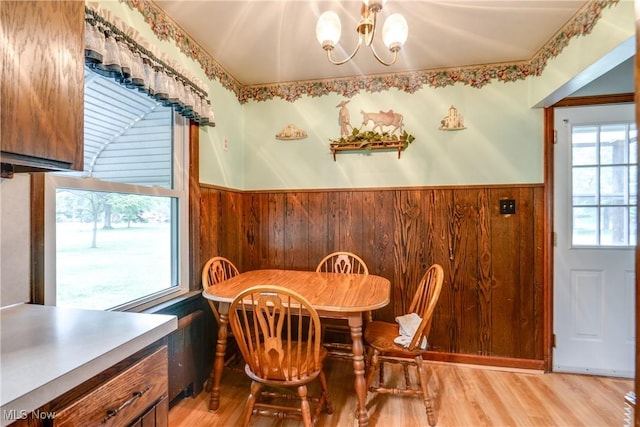 3985 Etter Rd, Mogadore, OH 44260 - dining area featuring a chandelier, a wainscoted wall, wood walls, and light wood finished floors