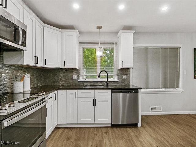 5265 Bellview St, Maple Heights, OH 44137 - kitchen featuring stainless steel appliances, light wood-style flooring, white cabinetry, backsplash, and recessed lighting