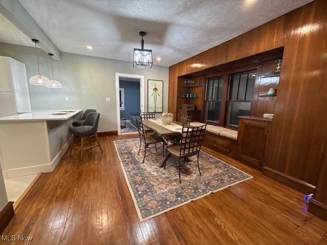 21430 Lakeshore Blvd, Euclid, OH 44123 - dining area featuring wood-type flooring and wooden walls