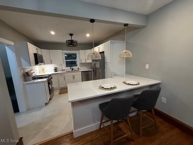 21430 Lakeshore Blvd, Euclid, OH 44123 - kitchen with white gas stove, black fridge, a peninsula, stainless steel dishwasher, and decorative backsplash