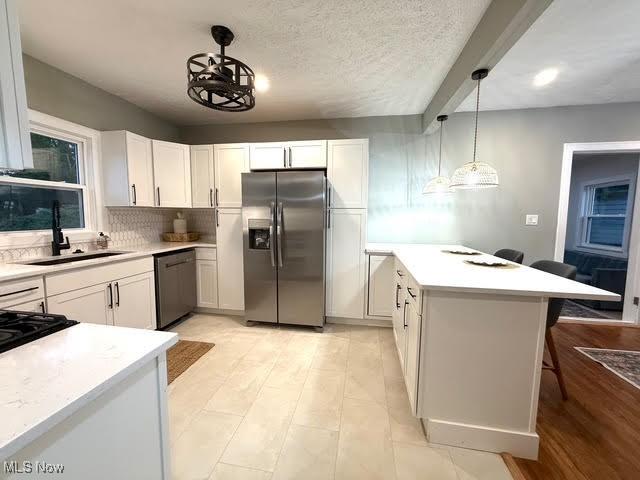 21430 Lakeshore Blvd, Euclid, OH 44123 - kitchen with appliances with stainless steel finishes, a peninsula, white cabinetry, and a breakfast bar area