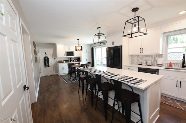 1524 Walker Rd, Follansbee, WV 26037 - kitchen featuring black refrigerator with ice dispenser, a kitchen bar, light countertops, healthy amount of natural light, and recessed lighting