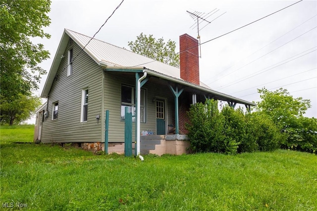 2461 Peters Creek Rd, Cambridge, OH 43725 - view of front facade with covered porch, a chimney, a metal roof, and a front lawn