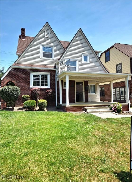 17405 Schenely Ave, Cleveland, OH 44119 - view of front of home featuring brick siding, a chimney, a front yard, and a porch