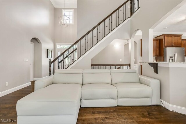 12110 Cora Ct, Concord, OH 44077 - living area with arched walkways, a high ceiling, and dark wood-style floors