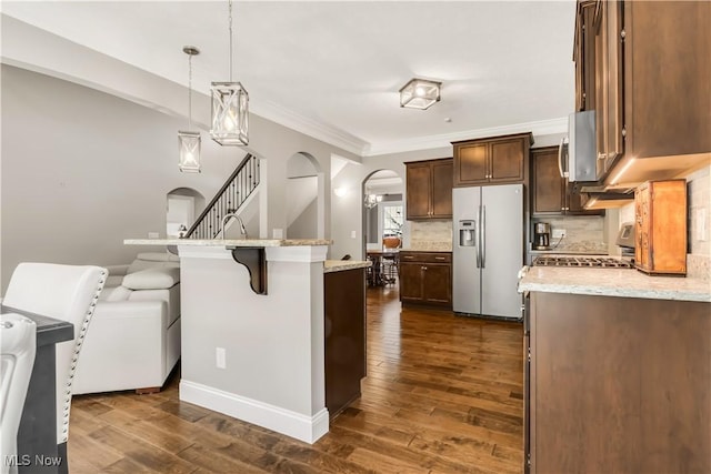 12110 Cora Ct, Concord, OH 44077 - kitchen with stainless steel appliances, arched walkways, dark wood-type flooring, tasteful backsplash, and ornamental molding