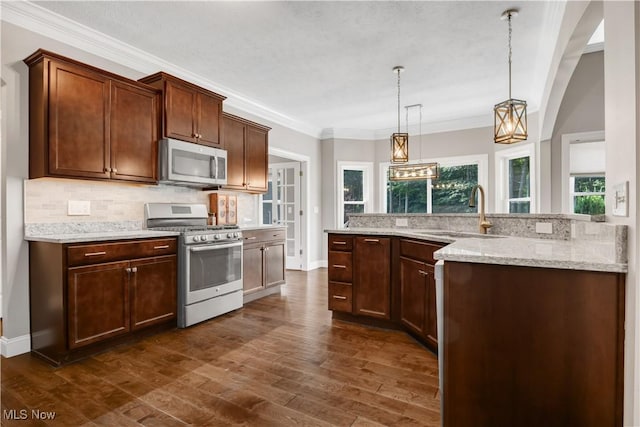 12110 Cora Ct, Concord, OH 44077 - kitchen with appliances with stainless steel finishes, backsplash, dark wood finished floors, decorative light fixtures, and ornamental molding