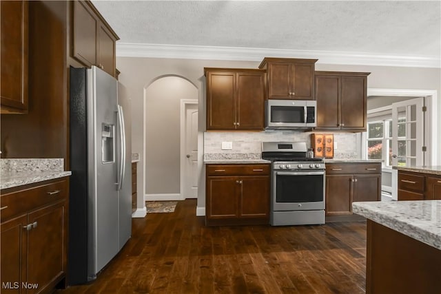 12110 Cora Ct, Concord, OH 44077 - kitchen featuring stainless steel appliances, ornamental molding, tasteful backsplash, light stone countertops, and dark wood finished floors