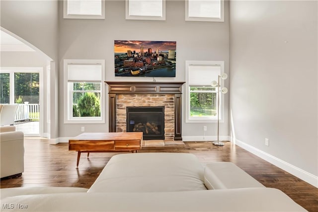 12110 Cora Ct, Concord, OH 44077 - living room featuring wood finished floors, a fireplace, healthy amount of natural light, a high ceiling, and arched walkways