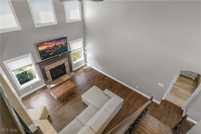12110 Cora Ct, Concord, OH 44077 - living area featuring wood finished floors, a stone fireplace, ceiling fan, and a high ceiling