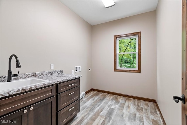 4720 Ashmont Ave SW, Canton, OH 44706 - laundry area with hookup for an electric dryer, cabinet space, washer hookup, and light wood-type flooring