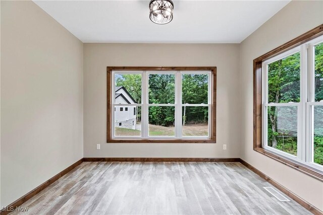 4720 Ashmont Ave SW, Canton, OH 44706 - unfurnished room with light wood finished floors and a chandelier