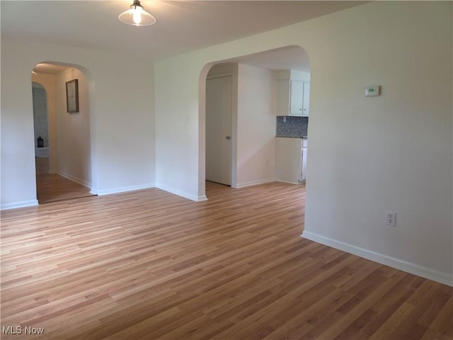 4581 Smith Stewart Rd, Vienna, OH 44473 - empty room featuring arched walkways and light wood-style flooring