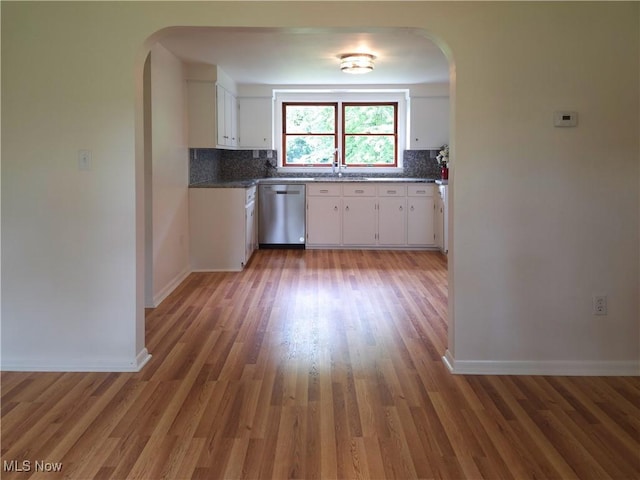4581 Smith Stewart Rd, Vienna, OH 44473 - kitchen with stainless steel dishwasher, arched walkways, light wood-style floors, and backsplash