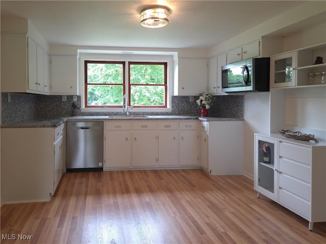 4581 Smith Stewart Rd, Vienna, OH 44473 - kitchen with stainless steel appliances, backsplash, light wood-style floors, and white cabinetry