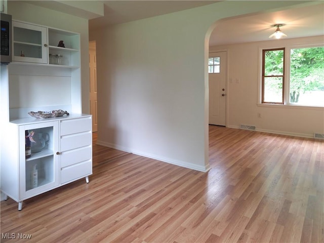 4581 Smith Stewart Rd, Vienna, OH 44473 - kitchen featuring arched walkways, light wood-style flooring, light countertops, open shelves, and stainless steel microwave