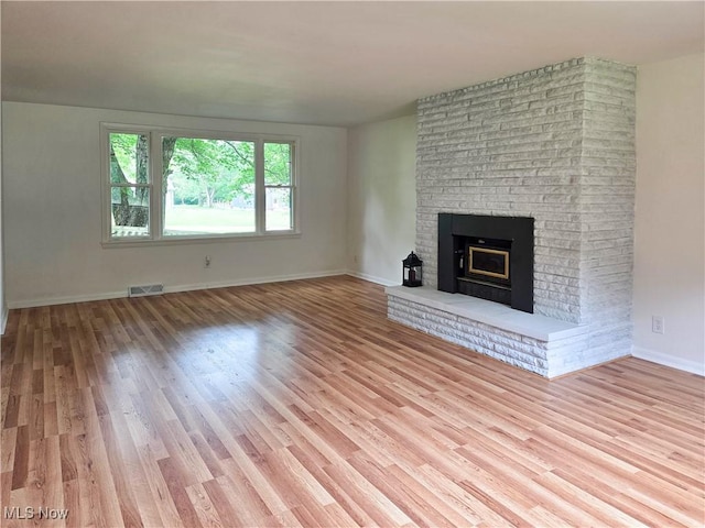 4581 Smith Stewart Rd, Vienna, OH 44473 - unfurnished living room with light wood-type flooring and a brick fireplace