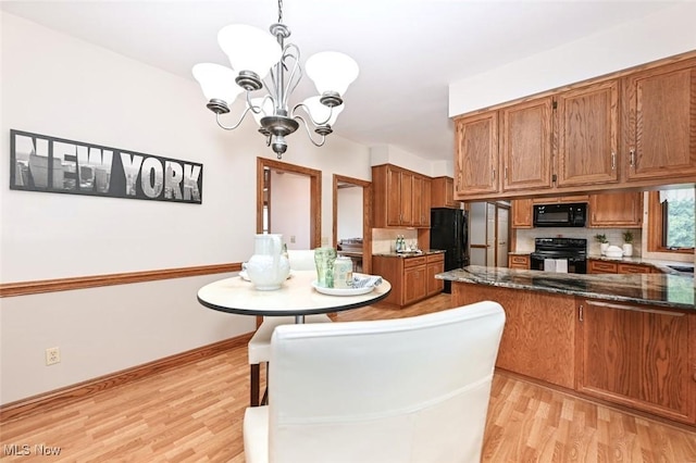 452 Herbert Rd, Akron, OH 44312 - kitchen featuring black appliances, brown cabinetry, light wood-style floors, a chandelier, and dark stone countertops