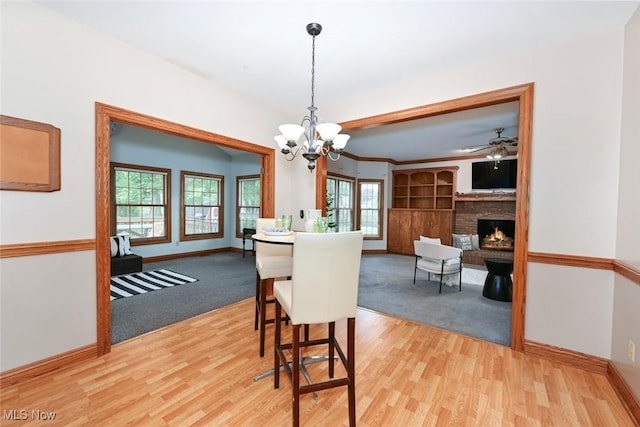 452 Herbert Rd, Akron, OH 44312 - dining room with light wood finished floors, plenty of natural light, a brick fireplace, and a chandelier
