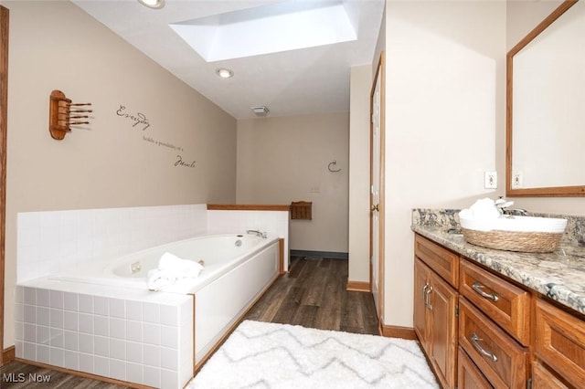 452 Herbert Rd, Akron, OH 44312 - full bathroom featuring a skylight, vanity, a jetted tub, and wood finished floors