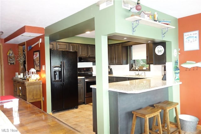 3545 Malley Ave, Coventry Township, OH 44319 - kitchen featuring black fridge with ice dispenser, stainless steel electric range, under cabinet range hood, dark brown cabinetry, and a peninsula