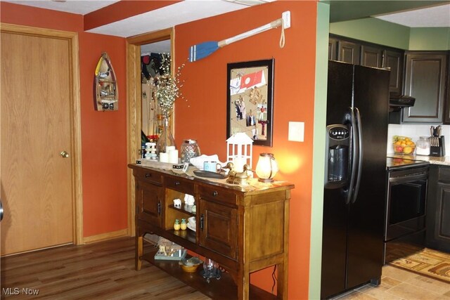 3545 Malley Ave, Coventry Township, OH 44319 - kitchen featuring black fridge, range with electric stovetop, under cabinet range hood, and light wood finished floors