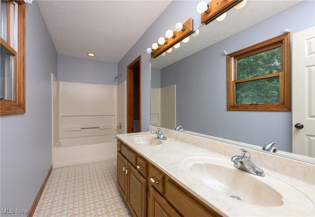 6104 Shipslanding Ave NW, Canton, OH 44718 - bathroom featuring double vanity, tile patterned floors, a textured ceiling, and washtub / shower combination
