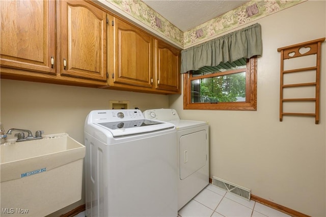 6104 Shipslanding Ave NW, Canton, OH 44718 - laundry area featuring separate washer and dryer, cabinet space, and light tile patterned floors