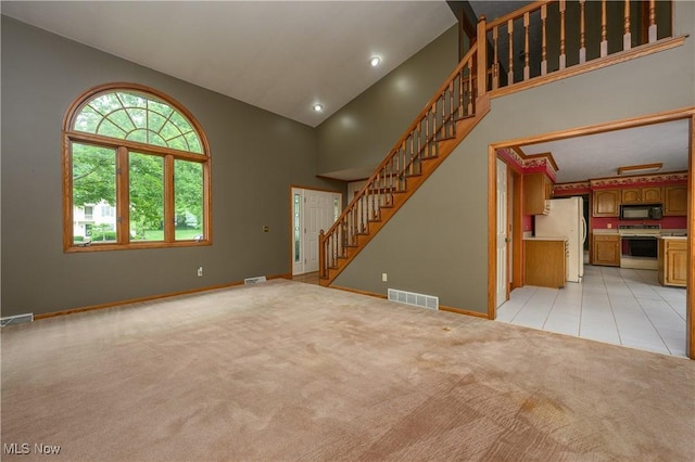 6104 Shipslanding Ave NW, Canton, OH 44718 - unfurnished living room featuring high vaulted ceiling, light colored carpet, and stairway