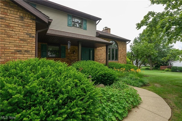 6104 Shipslanding Ave NW, Canton, OH 44718 - doorway to property featuring a lawn, brick siding, and a chimney