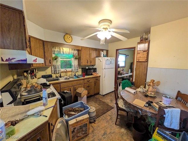 7567 Inland Dr, Olmsted Falls, OH 44138 - kitchen featuring freestanding refrigerator, brown cabinets, a ceiling fan, light countertops, and a wainscoted wall