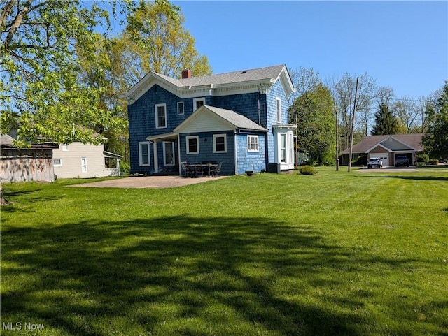 136 W Church St, Newton Falls, OH 44444 - rear view of property featuring a chimney, a lawn, and a patio