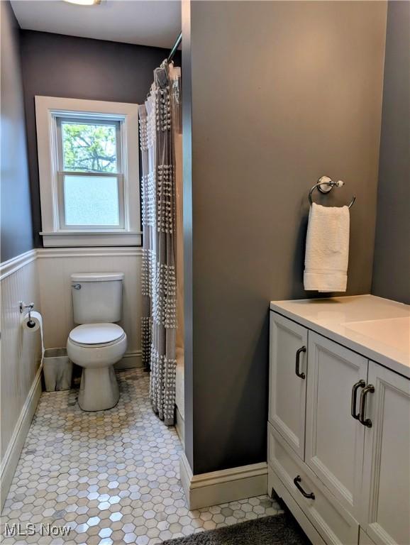 136 W Church St, Newton Falls, OH 44444 - bathroom with vanity, a shower with curtain, wainscoting, and tile patterned floors