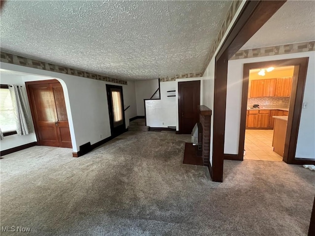 3731 Washington Park Blvd, Newburgh Heights, OH 44105 - unfurnished living room with a textured ceiling, carpet, and arched walkways