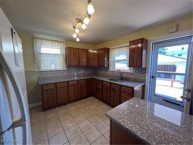 3731 Washington Park Blvd, Newburgh Heights, OH 44105 - kitchen featuring light tile patterned flooring, backsplash, dark stone counters, and rail lighting