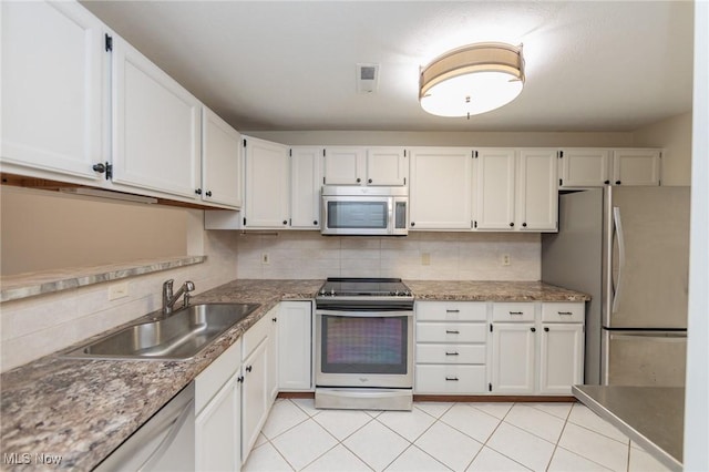 6131 Center St Unit 106, Mentor, OH 44060 - kitchen featuring stainless steel appliances, decorative backsplash, white cabinetry, light tile patterned floors, and light stone countertops