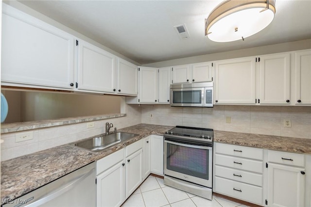6131 Center St Unit 106, Mentor, OH 44060 - kitchen with stainless steel appliances, tasteful backsplash, and white cabinetry