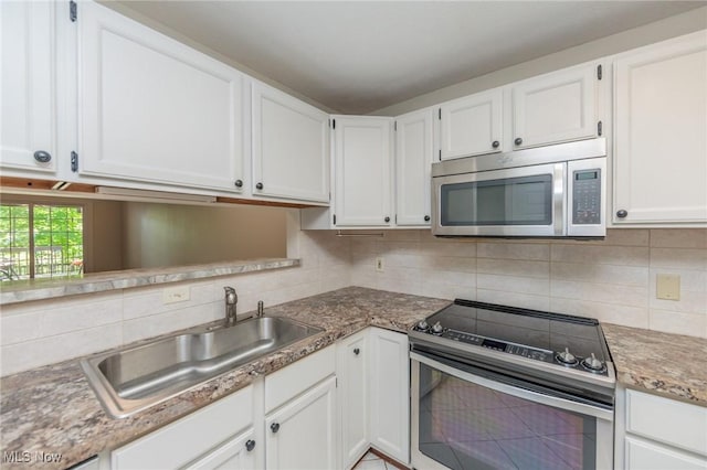 6131 Center St Unit 106, Mentor, OH 44060 - kitchen featuring appliances with stainless steel finishes, decorative backsplash, and white cabinets
