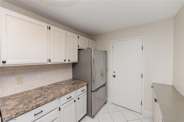 6131 Center St Unit 106, Mentor, OH 44060 - kitchen featuring freestanding refrigerator, decorative backsplash, white cabinets, and stone countertops