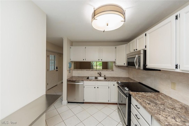 6131 Center St Unit 106, Mentor, OH 44060 - kitchen featuring appliances with stainless steel finishes, decorative backsplash, white cabinets, and light tile patterned floors