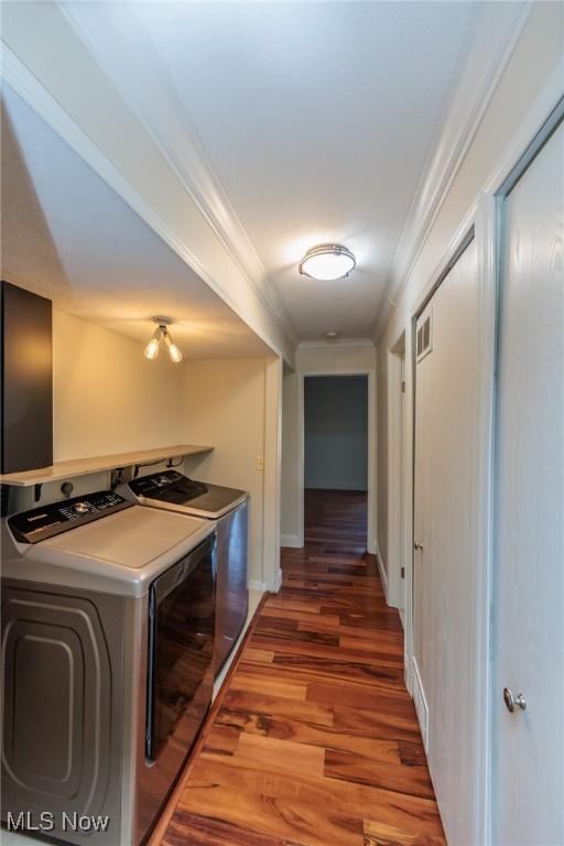 6131 Center St Unit 106, Mentor, OH 44060 - laundry room featuring washer and clothes dryer, ornamental molding, and wood finished floors
