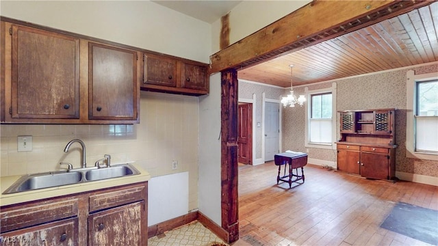 1811 Randolph Rd, Mogadore, OH 44260 - kitchen featuring wallpapered walls, a chandelier, backsplash, hanging light fixtures, and light wood-style floors