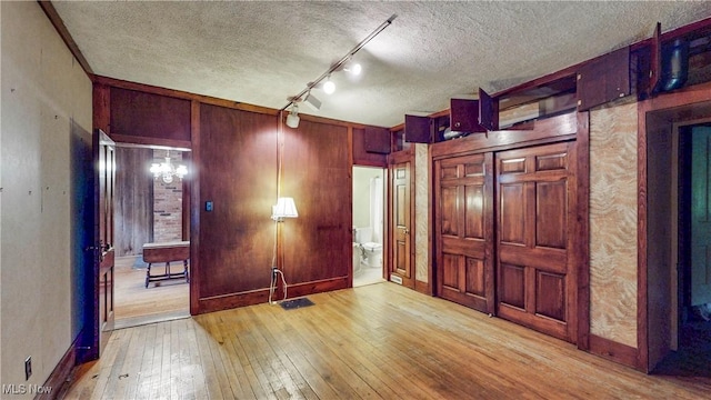 1811 Randolph Rd, Mogadore, OH 44260 - unfurnished bedroom with hardwood / wood-style flooring, a textured ceiling, wood walls, and ensuite bathroom